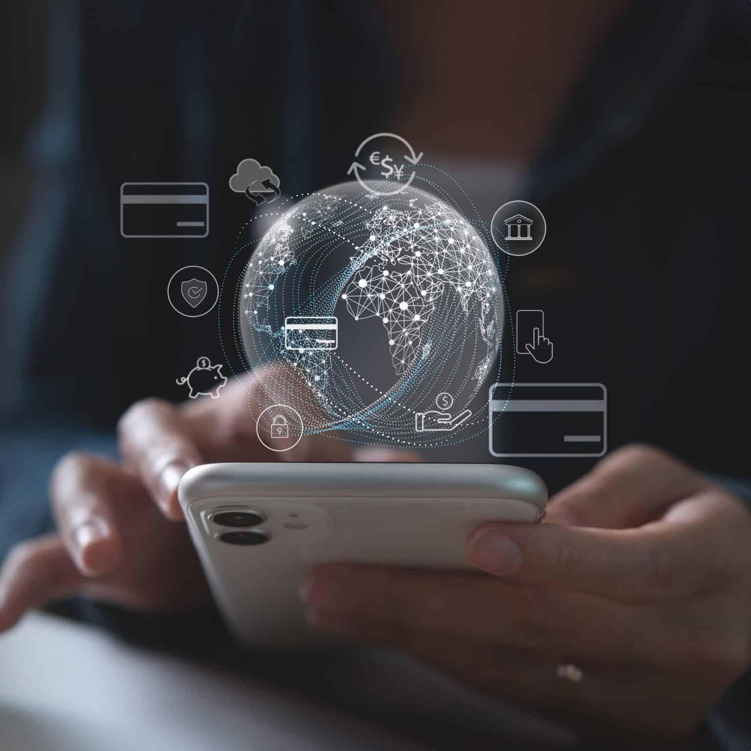 Person using a smartphone with a digital globe and payment icons representing global digital transactions.